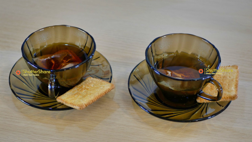 Two Cups of Tea with Biscuits on Amber Saucers
