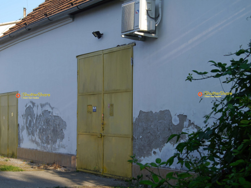 Weathered Building with Yellow Metal Doors